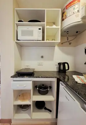 a kitchen with a stove and a microwave at Tu lugar en Nueva Córdoba!A 50 mtros del Sanatorio Acongagua in Cordoba