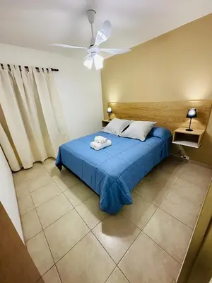 a bedroom with a blue bed and a ceiling fan at Departamento premium, la mejor zona de Nueva Córdoba in Cordoba