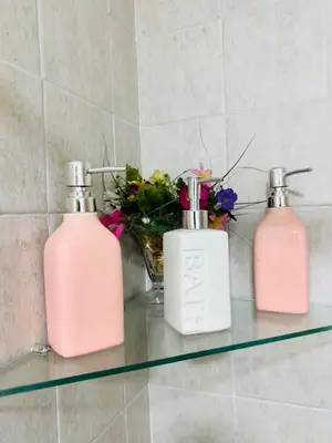 three bottles on a glass shelf in a bathroom at Departamento premium, la mejor zona de Nueva Córdoba in Cordoba