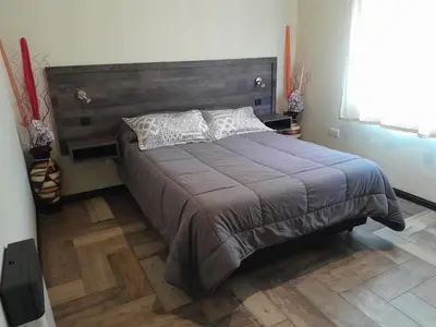 a bedroom with a large bed with a wooden headboard at Chalet El Buho in Villa General Belgrano