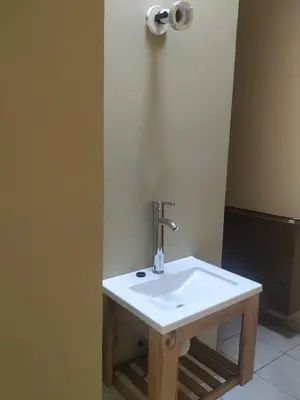 a white sink in a bathroom with a roll of toilet paper at Departamentos Centro in Villa Dolores