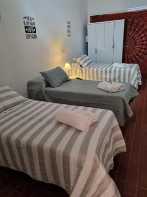 three beds with towels on them in a room at MAILY Guest House in Alta Gracia
