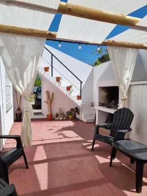 a patio with two chairs and a fireplace at MAILY Guest House in Alta Gracia