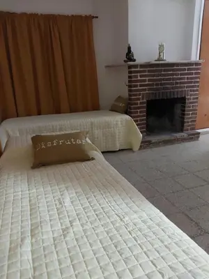 a bedroom with two beds and a fireplace at MAILY Guest House in Alta Gracia