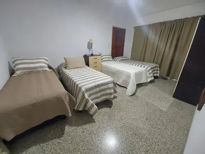 a bedroom with two beds and a dresser in it at MAILY Guest House in Alta Gracia
