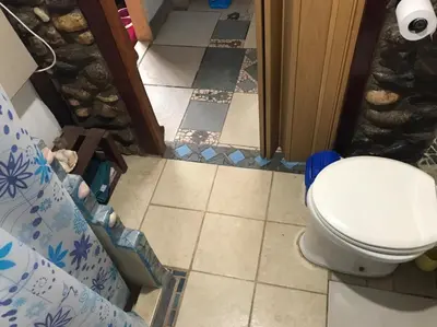 a bathroom with a toilet and a tile floor at Casa Sol y Luna in Villa General Belgrano