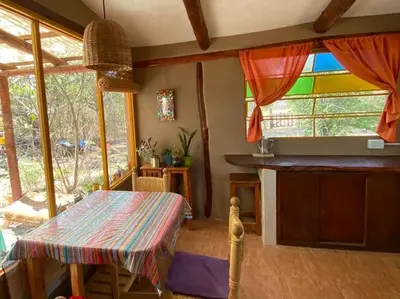 a dining room with a table and some windows at Casa Sol y Luna in Villa General Belgrano