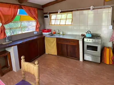 a small kitchen with a stove and a window at Casa Sol y Luna in Villa General Belgrano