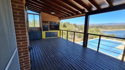 a large deck with a kitchen and a view of the water at Casa del Lago in Potrero de Garay