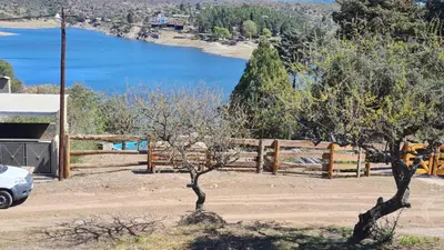 two trees in front of a fence with a lake at Casa del Lago in Potrero de Garay