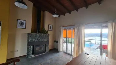 a living room with a fireplace and a balcony at Casa del Lago in Potrero de Garay
