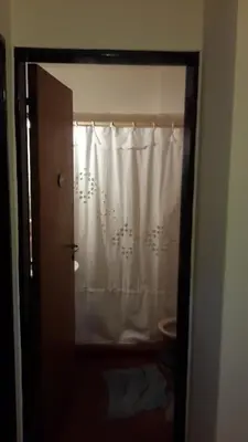 a bathroom with a white shower curtain and a toilet at Departamento Córdoba in Cordoba