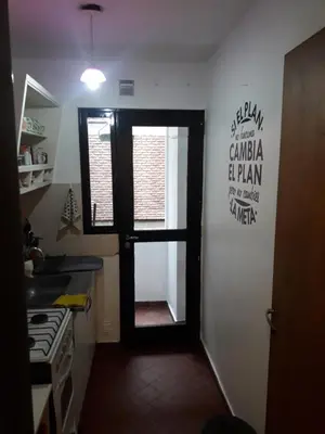 a kitchen with a door open to a kitchen with a stove at Departamento Córdoba in Cordoba