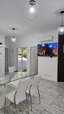 a dining room with a glass table and white chairs at RaGi dpto 4 in Cordoba