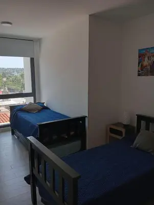 a bedroom with two beds and a large window at Gran Duplex Paseo Quattro 22 (centrico) - Cochera + Pileta in Villa Carlos Paz