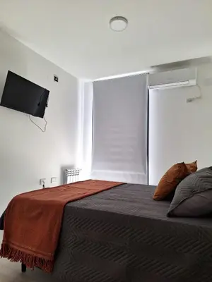 a bedroom with a bed with a cat laying on it at Gran Duplex Paseo Quattro 22 (centrico) - Cochera + Pileta in Villa Carlos Paz