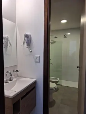 a bathroom with a sink and a toilet and a shower at Gran Duplex Paseo Quattro 22 (centrico) - Cochera + Pileta in Villa Carlos Paz
