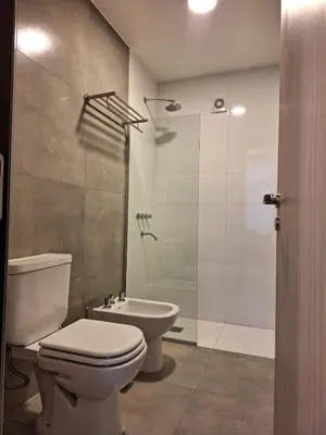 a bathroom with a toilet and a shower and a sink at Gran Duplex Paseo Quattro 22 (centrico) - Cochera + Pileta in Villa Carlos Paz