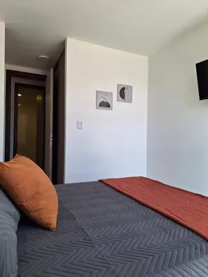 a bedroom with a bed with two pictures on the wall at Gran Duplex Paseo Quattro 22 (centrico) - Cochera + Pileta in Villa Carlos Paz