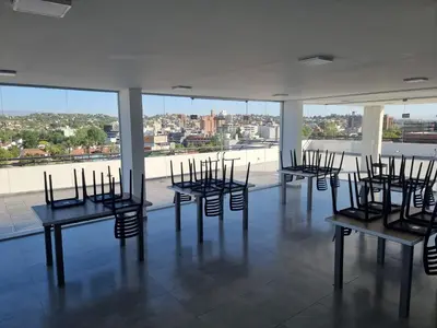 a group of chairs sitting in a room with windows at Gran Duplex Paseo Quattro 22 (centrico) - Cochera + Pileta in Villa Carlos Paz