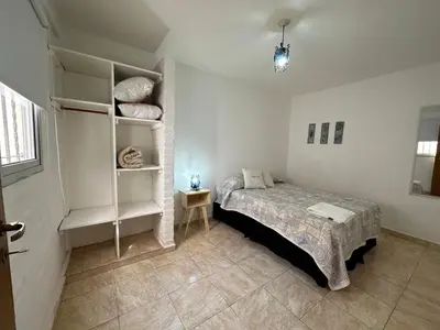 a bedroom with a bed and a book shelf at CONFORTABLE Dpto. Pasaje Tucumán in Alta Gracia