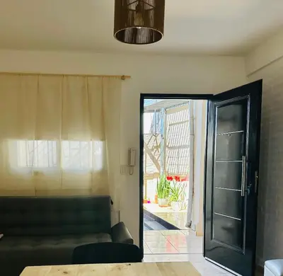 a living room with a black door and a couch at CONFORTABLE Dpto. Pasaje Tucumán in Alta Gracia