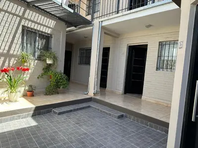 a porch of a house with potted plants at CONFORTABLE Dpto. Pasaje Tucumán in Alta Gracia
