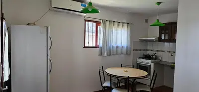 a small kitchen with a table and a refrigerator at Hospedaje Resiliencia in Cordoba
