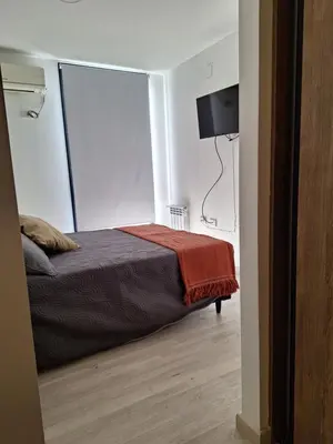 a bedroom with a bed and a flat screen tv at Gran Duplex Paseo Quattro 21 (centrico) - Cochera + Pileta in Villa Carlos Paz