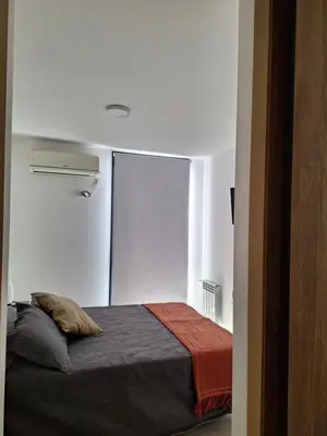 a bedroom with a bed in a white room at Gran Duplex Paseo Quattro 21 (centrico) - Cochera + Pileta in Villa Carlos Paz