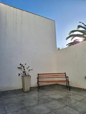 a bench sitting next to a wall with a plant at Gran Duplex Paseo Quattro 21 (centrico) - Cochera + Pileta in Villa Carlos Paz
