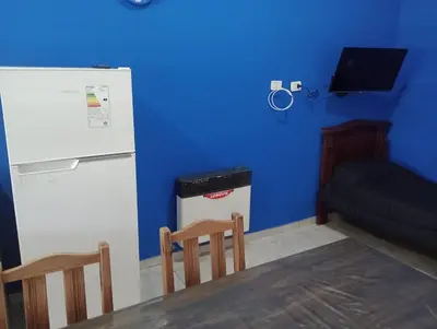 a kitchen with a refrigerator and a table and chairs at Complejo Bru-Mar in Los Olivares
