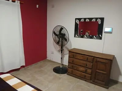 a room with a fan and a wooden dresser at Complejo Bru-Mar in Los Olivares
