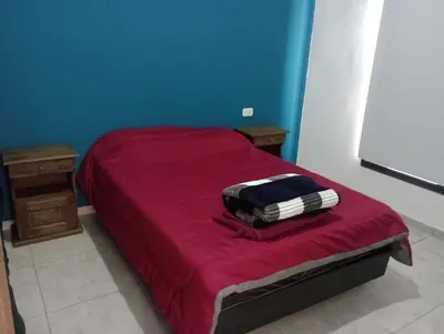 a bedroom with a red bed with a red blanket at Complejo Bru-Mar in Los Olivares