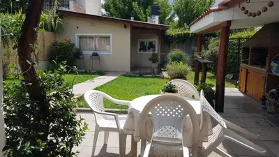 a white table and chairs in a garden at Las Lavandas Tranquilidad cerca de todo in Mina Clavero