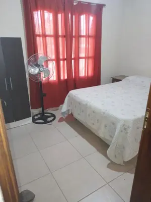 a bedroom with a bed and a fan and a window at Cabaña Corcovado in El Parador