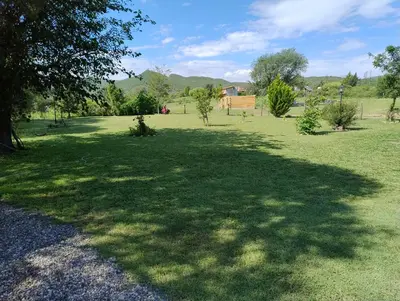 a large grass field with trees in the middle at Cabaña Corcovado in El Parador