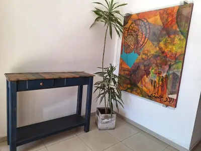 a table and a plant next to a painting at Departamento Cofico in Cordoba