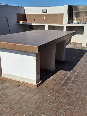 a large wooden table sitting on top of a brick floor at Departamento Cofico in Cordoba