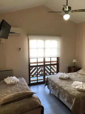 a bedroom with two beds and a window with a view at Hotel Lihuel in Villa Carlos Paz