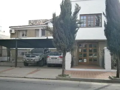 a house with two cars parked in front of it at Hotel Lihuel in Villa Carlos Paz