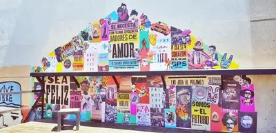a wall with a building covered in stickers at Rivera Hostel Córdoba in Cordoba