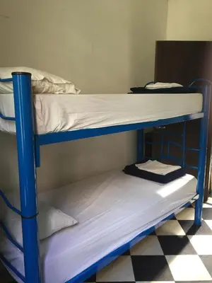 two bunk beds in a room with a checkered floor at Rivera Hostel Córdoba in Cordoba