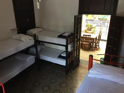 a room with bunk beds and a table with a dining room at Rivera Hostel Córdoba in Cordoba
