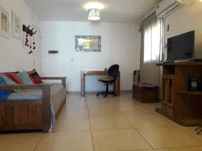a living room with a bed and a desk with a television at Espacio C San Juan con cochera in Cordoba