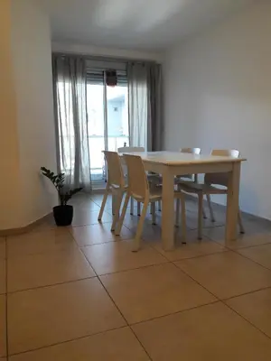 a wooden table and chairs in a room with a window at Espacio C San Juan con cochera in Cordoba
