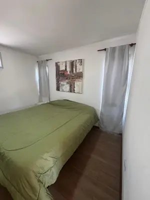 a small bedroom with a green bed in it at Hermoso departamento in Villa Carlos Paz