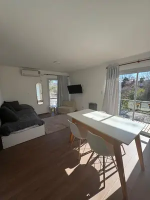 a living room with a table and a bed at Hermoso departamento in Villa Carlos Paz