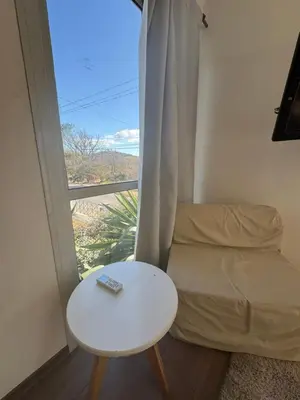 a room with a bed and a table and a window at Hermoso departamento in Villa Carlos Paz