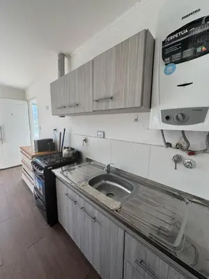 a kitchen with a sink and a stove at Hermoso departamento in Villa Carlos Paz